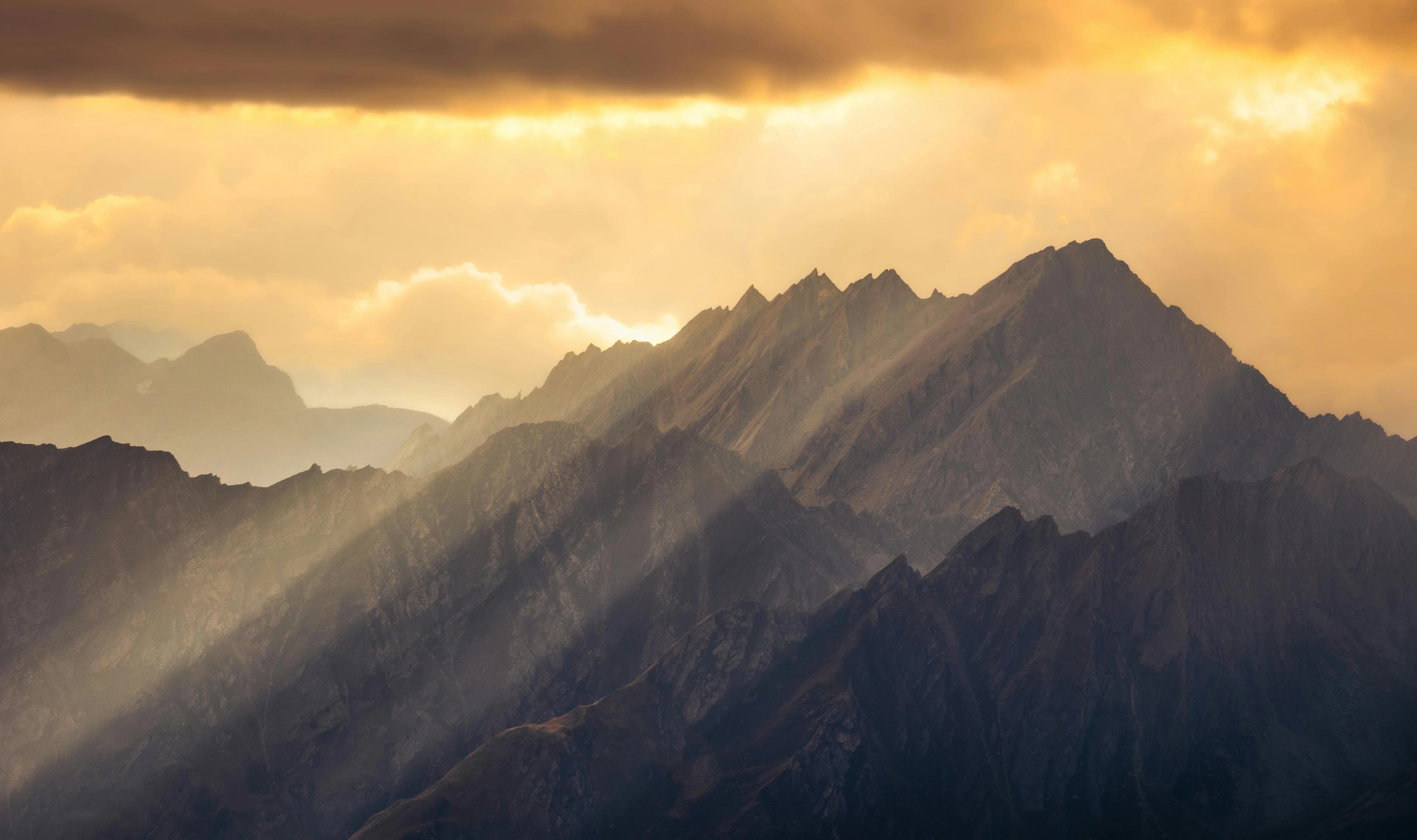 Sun shining through the clouds and mountains