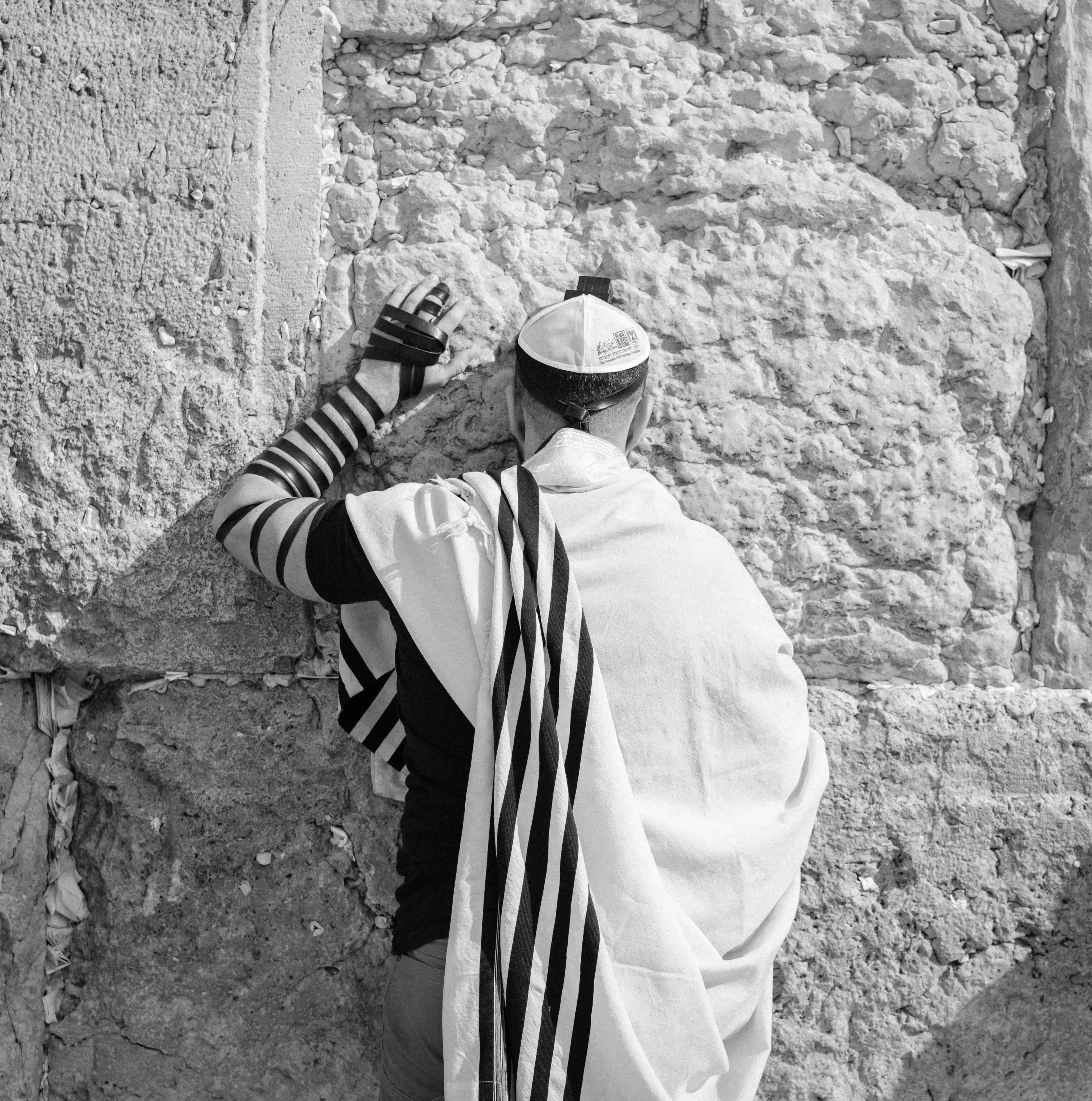 A man standing in front of a wall with hand on the wall