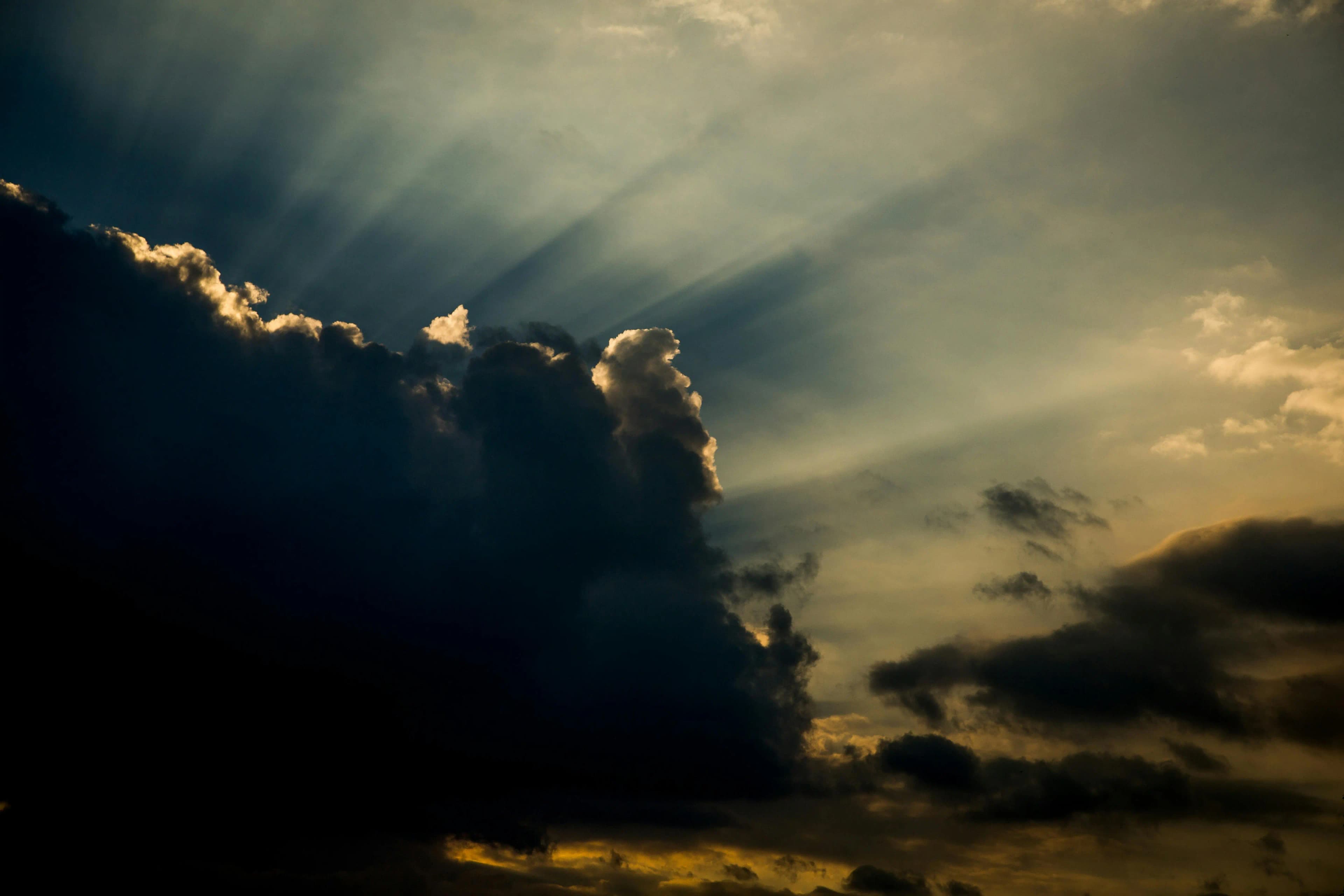 Dark storm cloud with sun rays breaking through the sky
